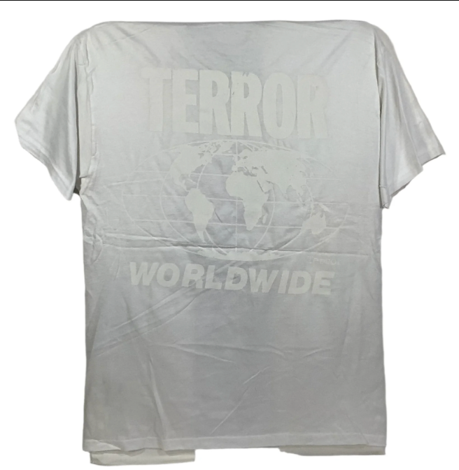 A white short-sleeve t-shirt with a faded, low-contrast graphic on the front featuring the word 'TERROR' above a world map outline and 'WORLDWIDE' below.